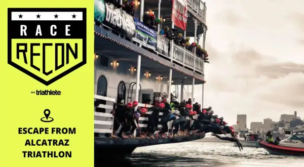 Athletes dive from a boat into the water for the Escape from Alcatraz Triathlon.