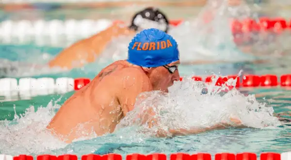 Ryan Lochte, wearing a blue "Florida" cap, powers through the water during intense swim workouts.