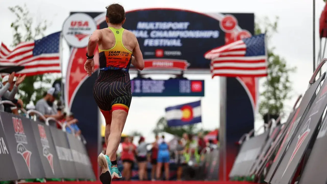 A triathlete runs towards the finish line at the USA Triathlon Multisport National Championships Festival, a testament to their USA Triathlon membership.