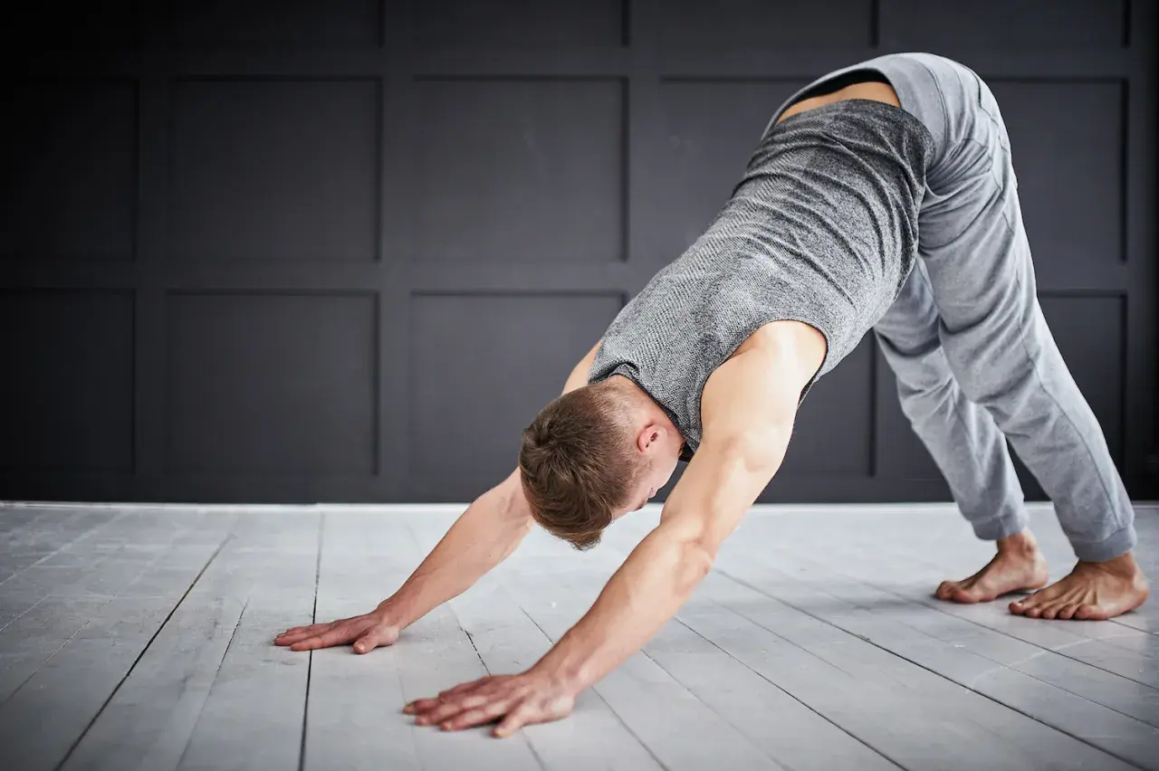 Man in downward-facing dog pose, a key stretch for yoga for triathletes, improving flexibility and recovery.