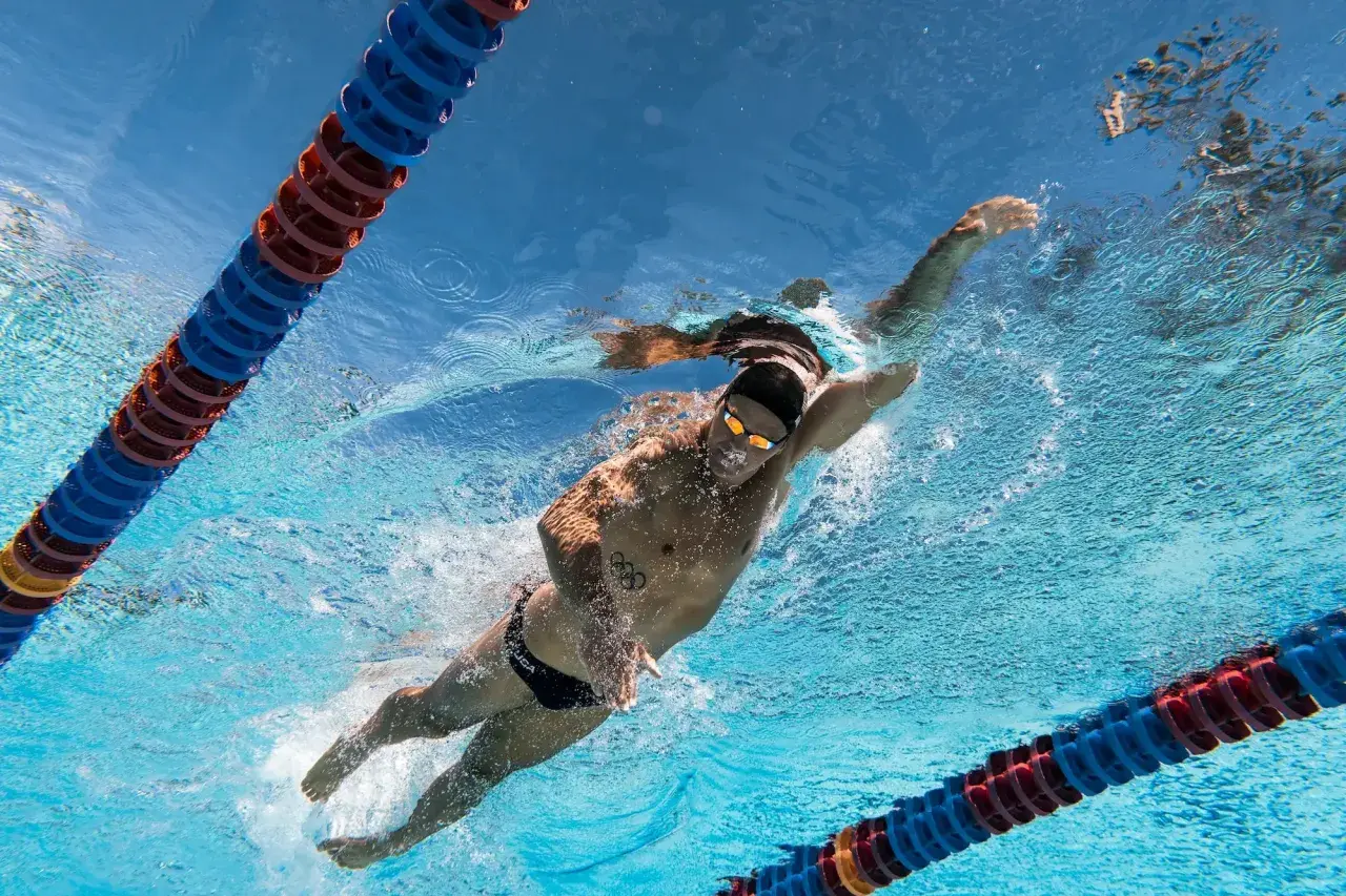 Underwater view of a swimmer performing the backstroke, with lane lines visible. Learn backstroke tips from this powerful stroke.