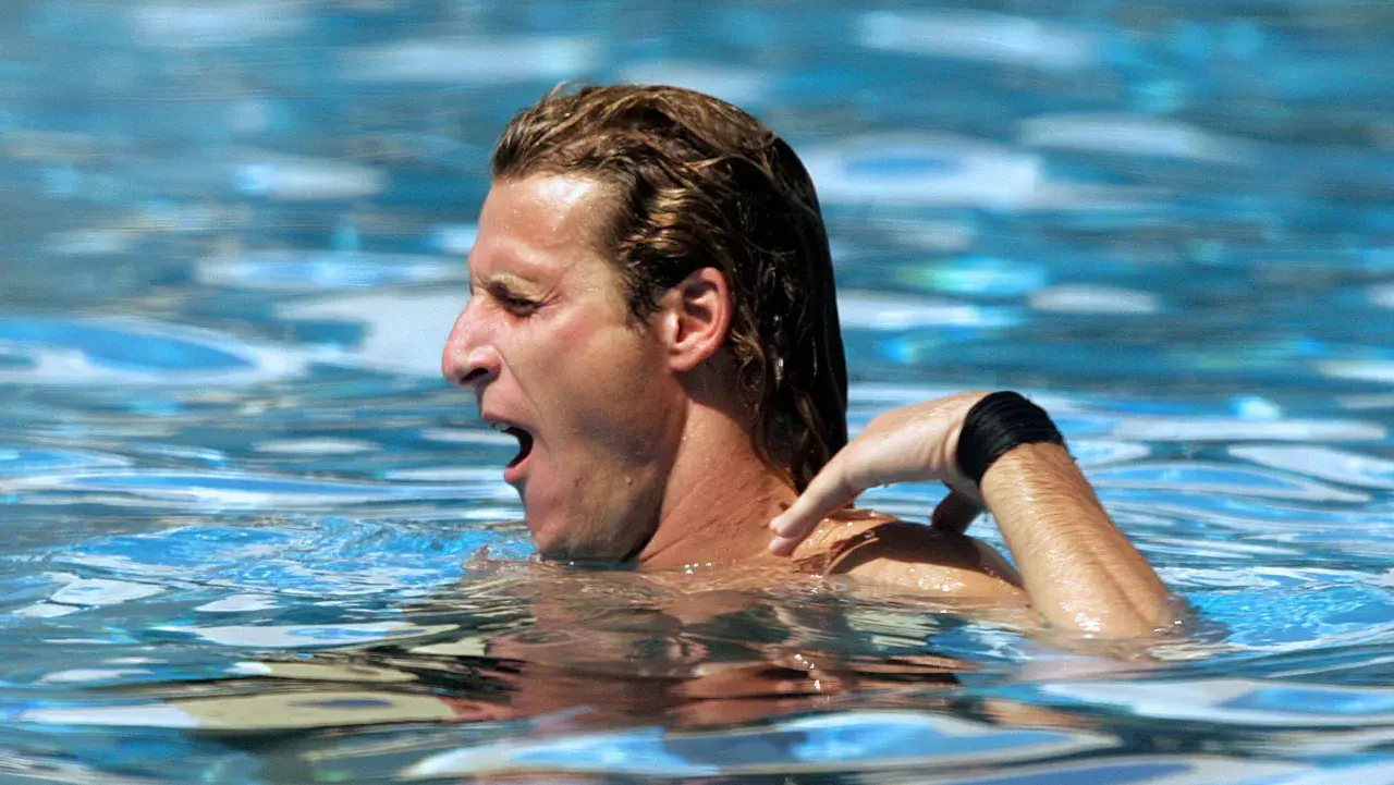 A swimmer gasps for air, his arm reaching back. The resistance of the water explains why does the pool make you tired.