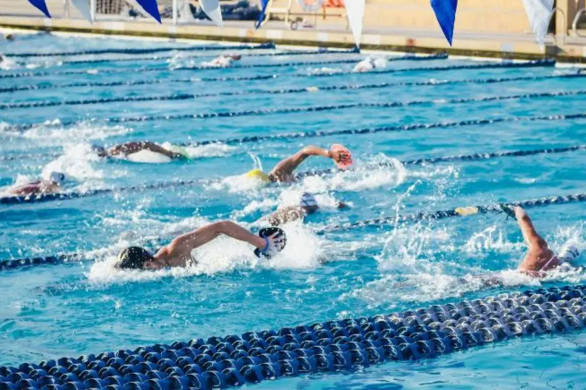 Swimmers push through the water in a competitive race, showcasing an intense hiit swim workout.
