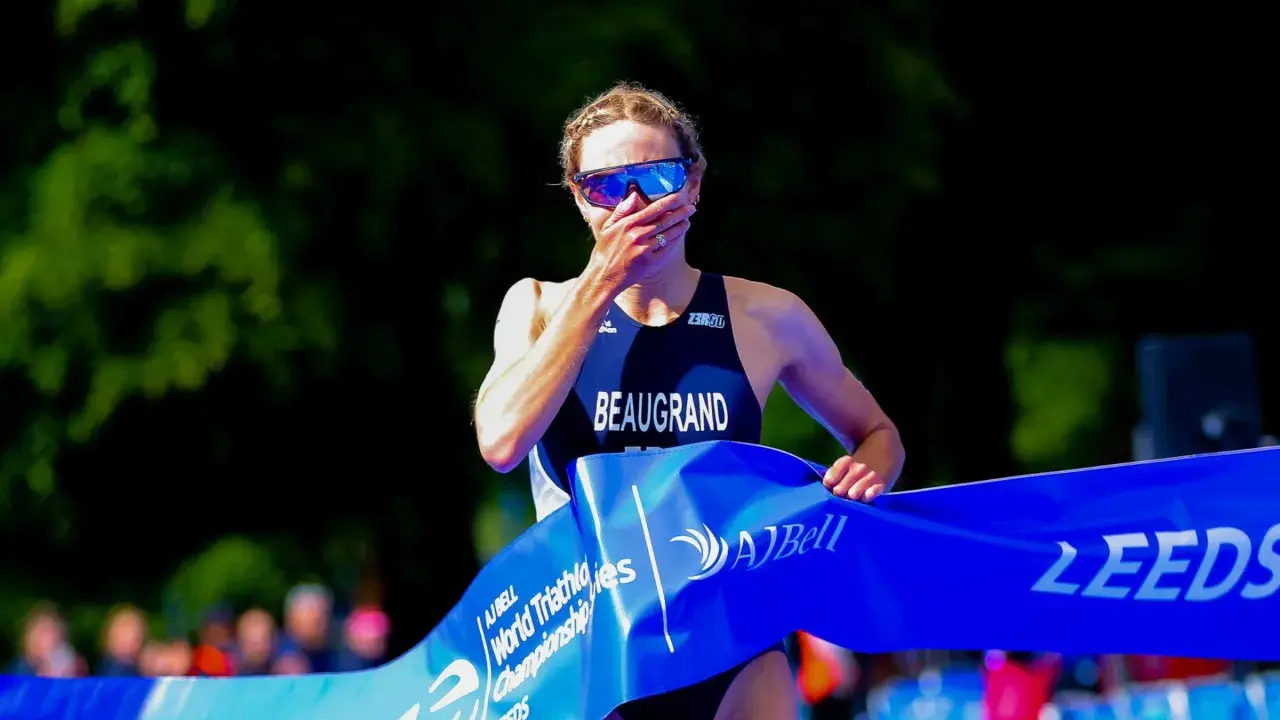 Cassandre Beaugrand, with hand over mouth, crosses the finish line at the World Triathlon Championship in Leeds, a moment of triumph and emotion.