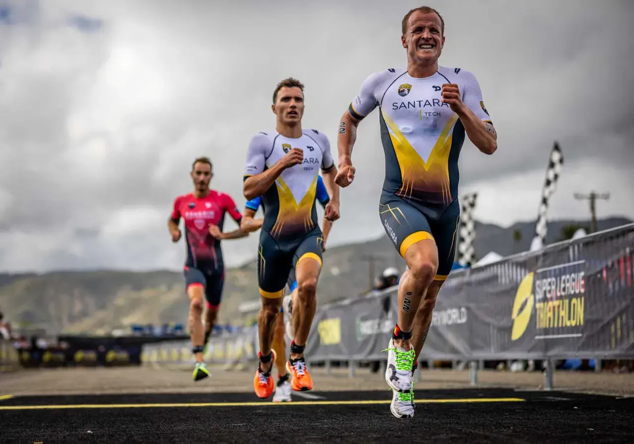Triathletes race, pushing their limits. The lead runner's determined face hints at the grueling Ironman triathlon distances ahead.