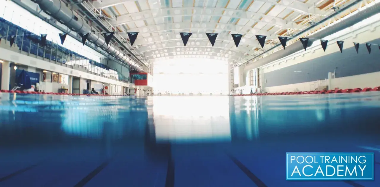 An empty indoor swimming pool with black Speedo flags. While chlorine kills many germs, does chlorine kill COVID?