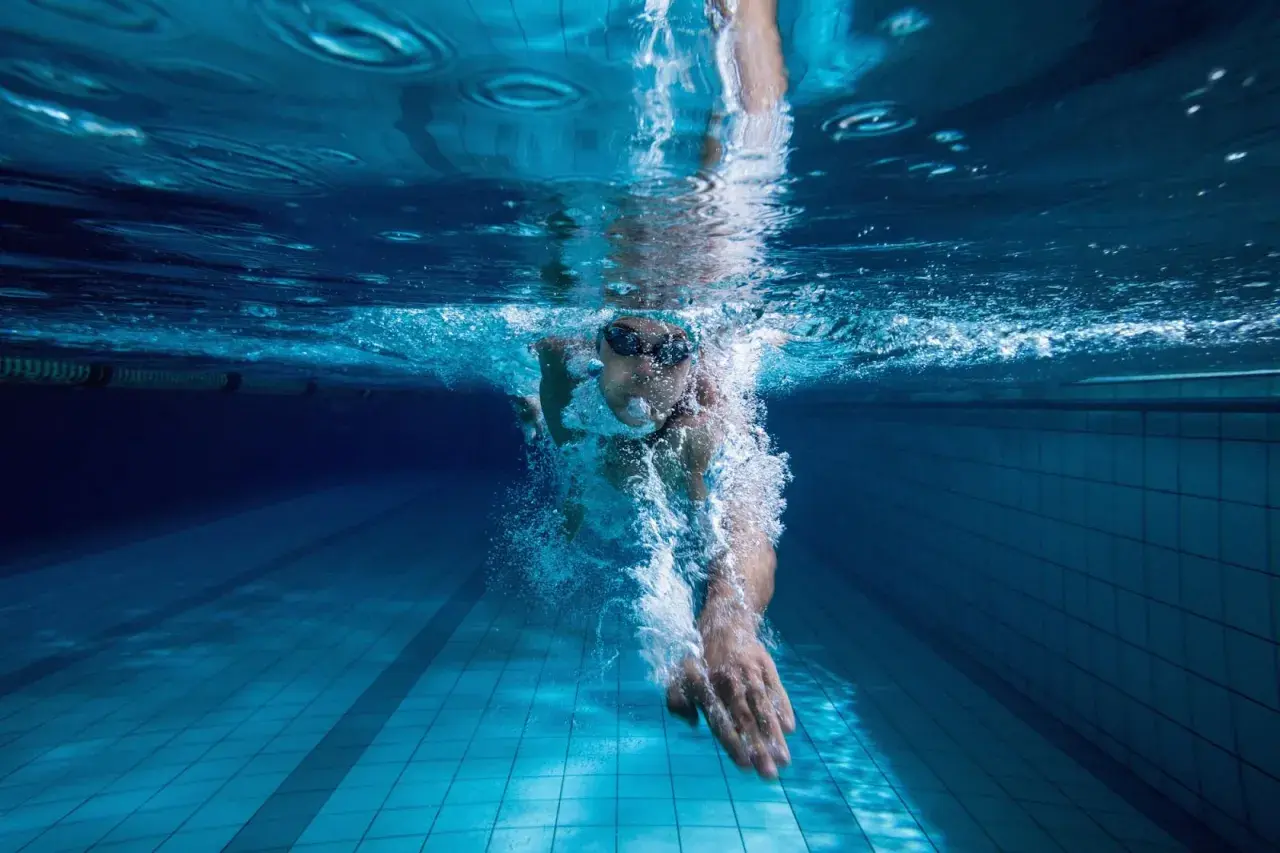 Underwater view of a swimmer pushing through the water, a powerful stroke for endurance swim workouts.