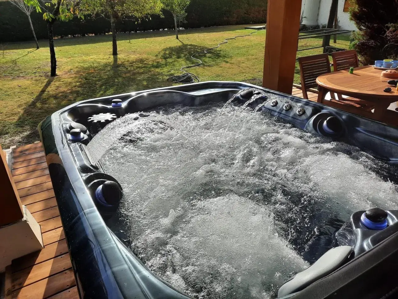 Bubbling hot tub on a sunny deck. Wondering how long after a tattoo can you go in a hot tub? This one looks inviting!