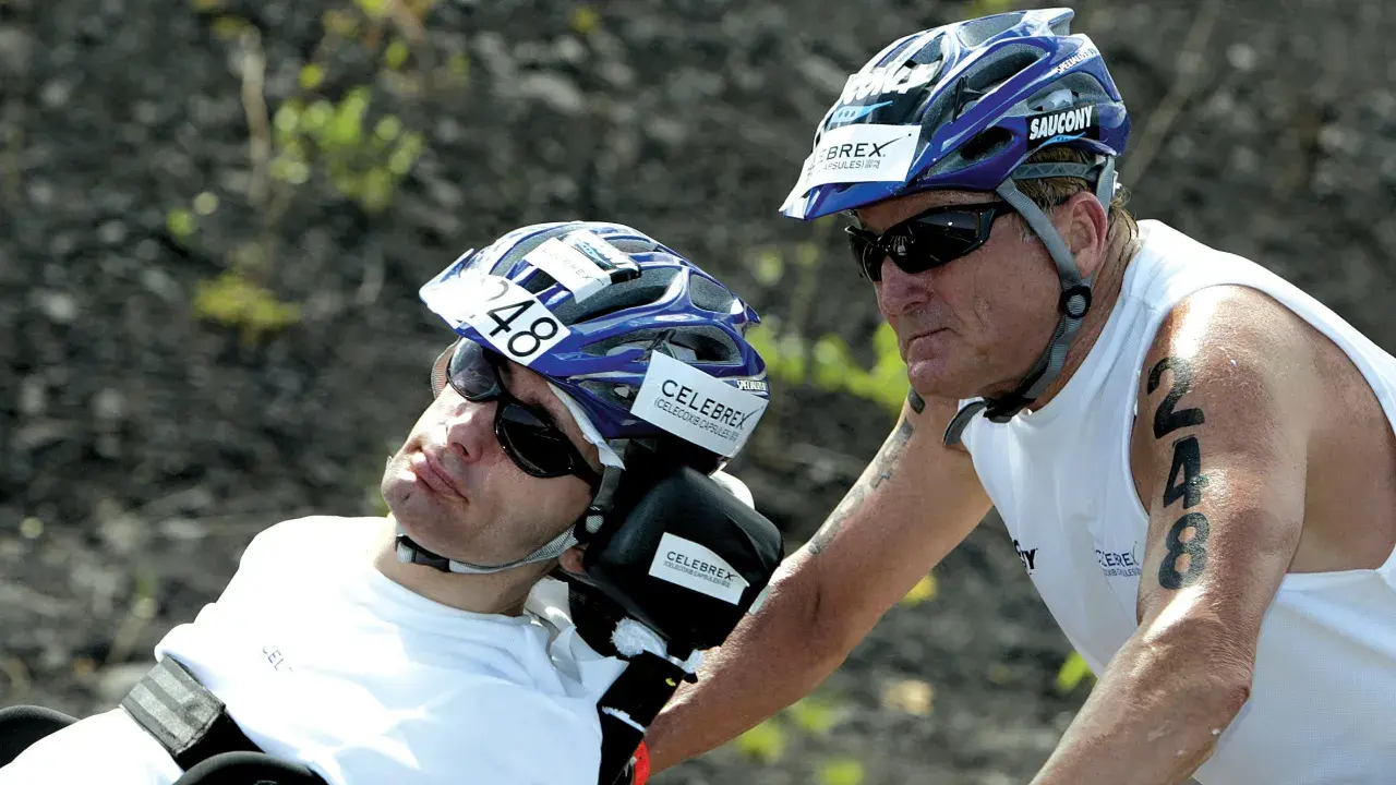 Dick Hoyt and his son Rick, a participant in the Ironman, wearing helmets and sunglasses. Rick has the number 48 on his helmet.