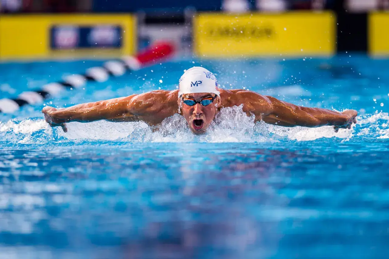 Michael Phelps powers through the water, his arms extended in a butterfly stroke, as if he could fly.