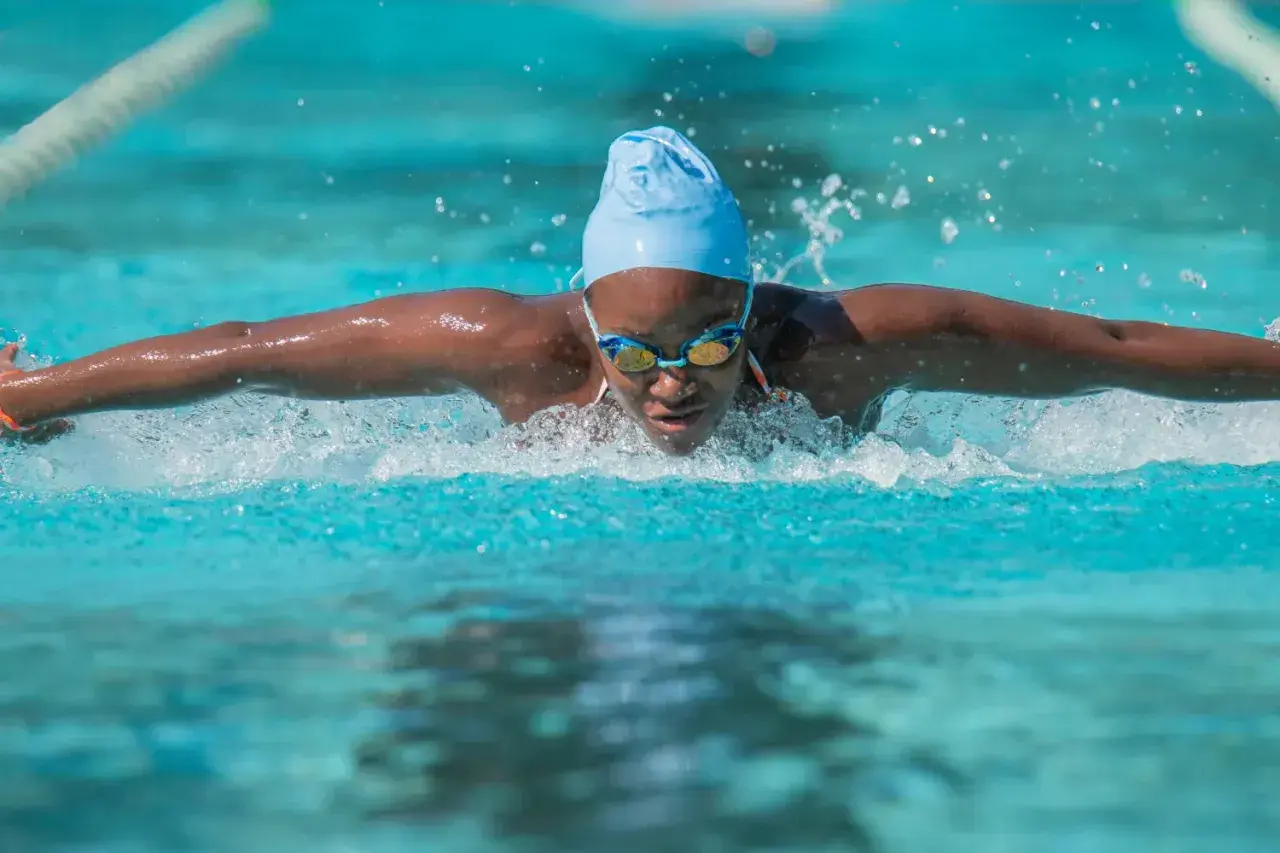 A swimmer powers through the water, a blur of motion and spray. This intense workout is a great way to burn swim calories.
