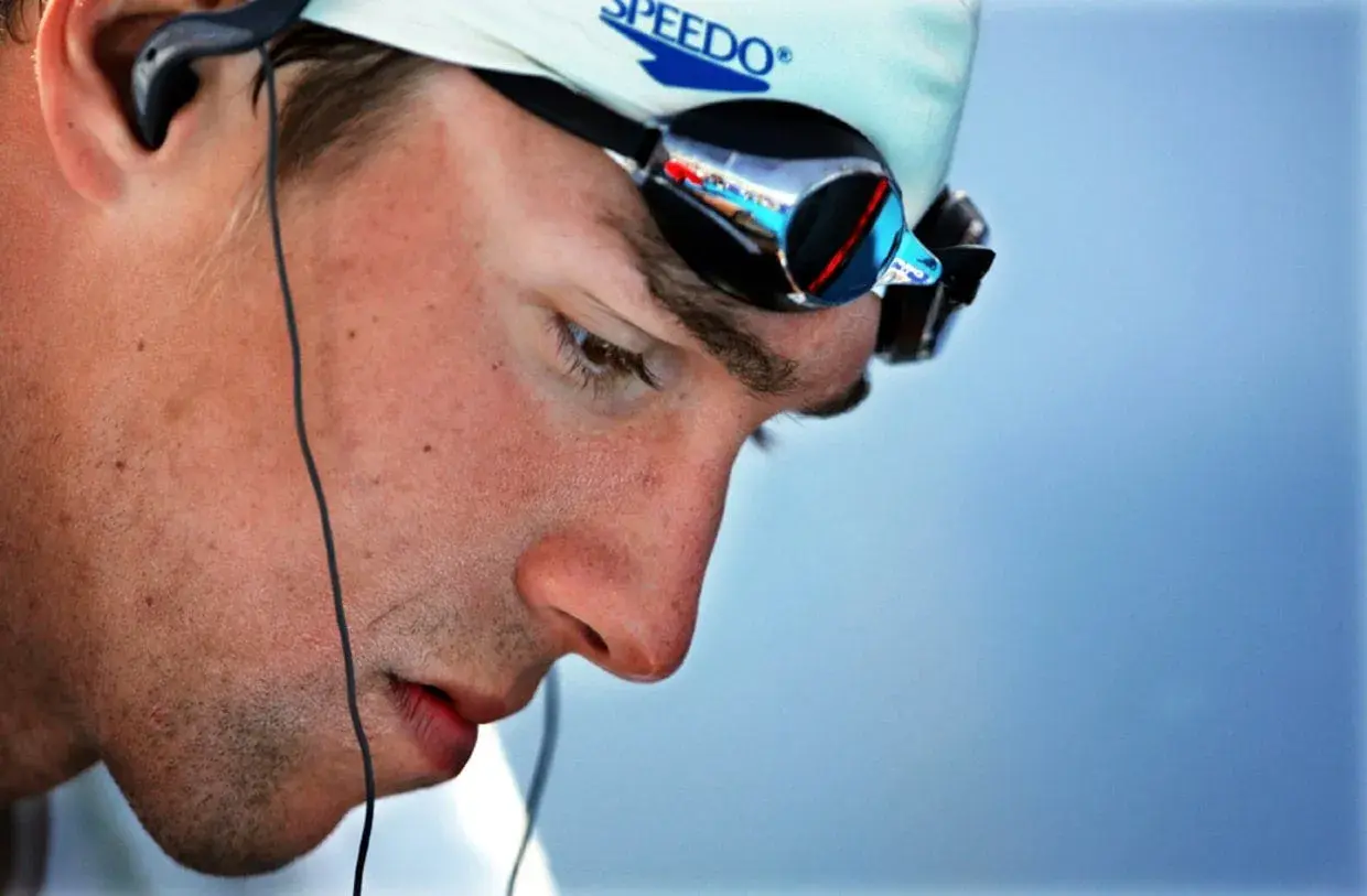 Michael Phelps in deep visualization, wearing Speedo cap and goggles, preparing for a race.