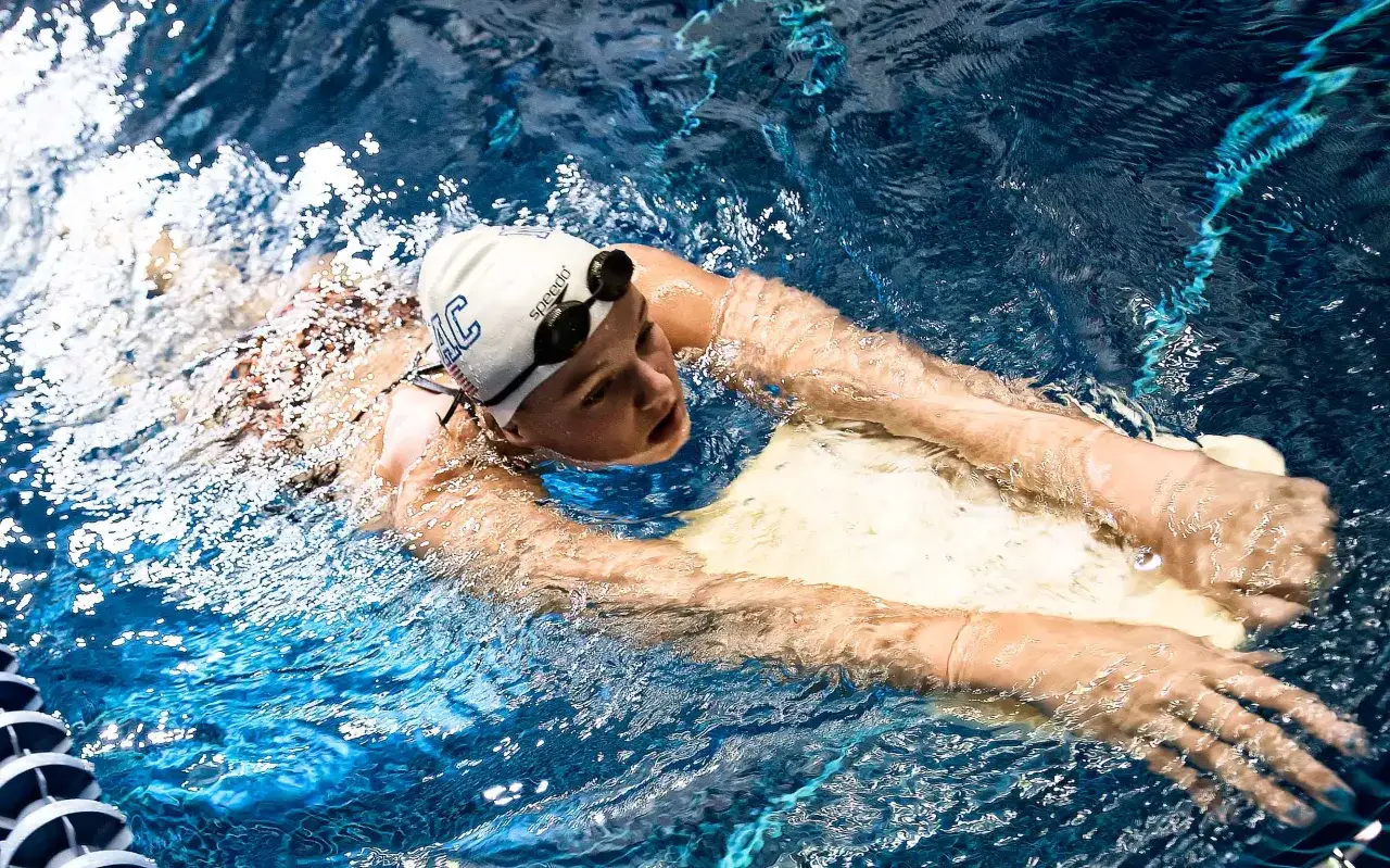 Swimmer practicing swim kick exercises with a kickboard, focused and determined.