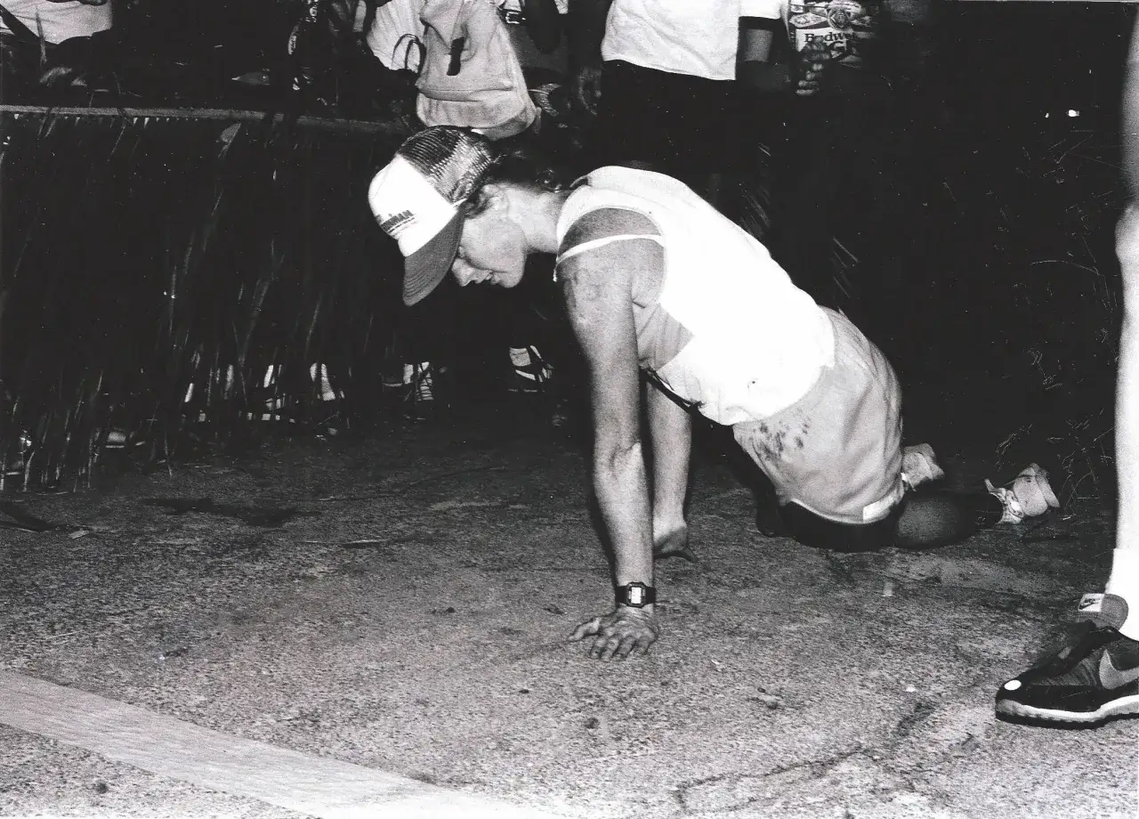 Julie Moss, the iconic Ironman triathlete, crawls towards the finish line, embodying sheer determination and the spirit of the Ironman race.