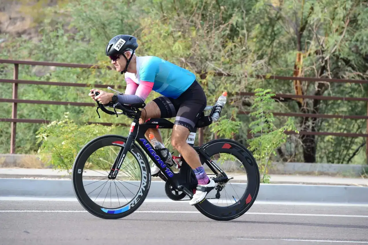 A cyclist in a triathlon training plan for beginners rides a time trial bike.