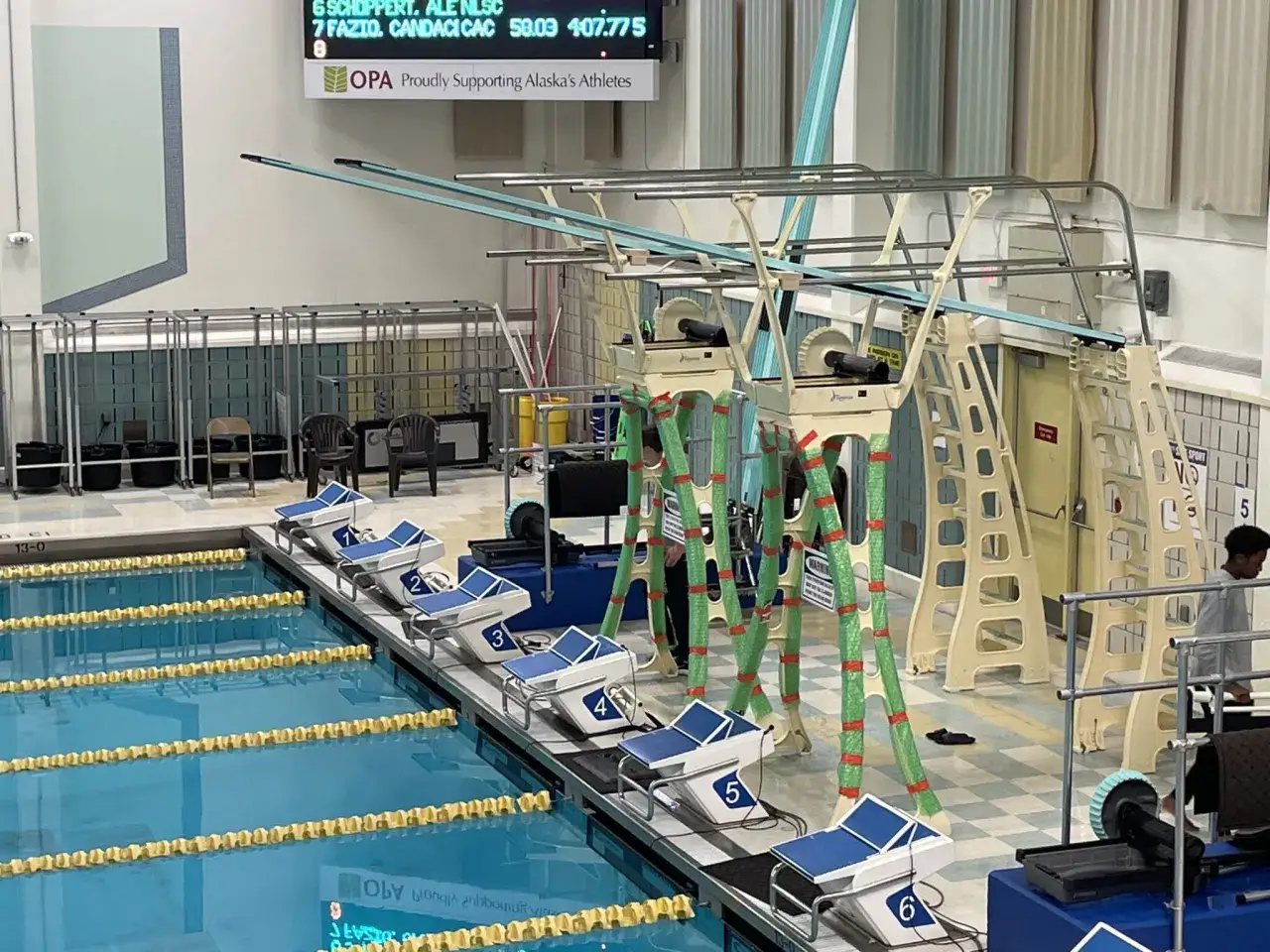 Multiple high diving boards stand over a swimming pool, ready for competition.
