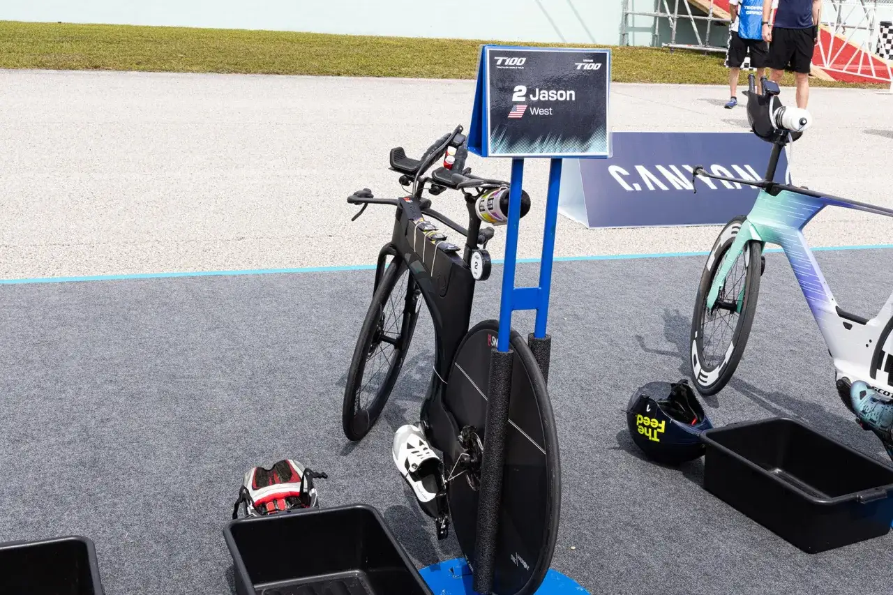 Triathlon transition areas with bikes ready for race day. Jason West's bike is marked with his name and number 2.
