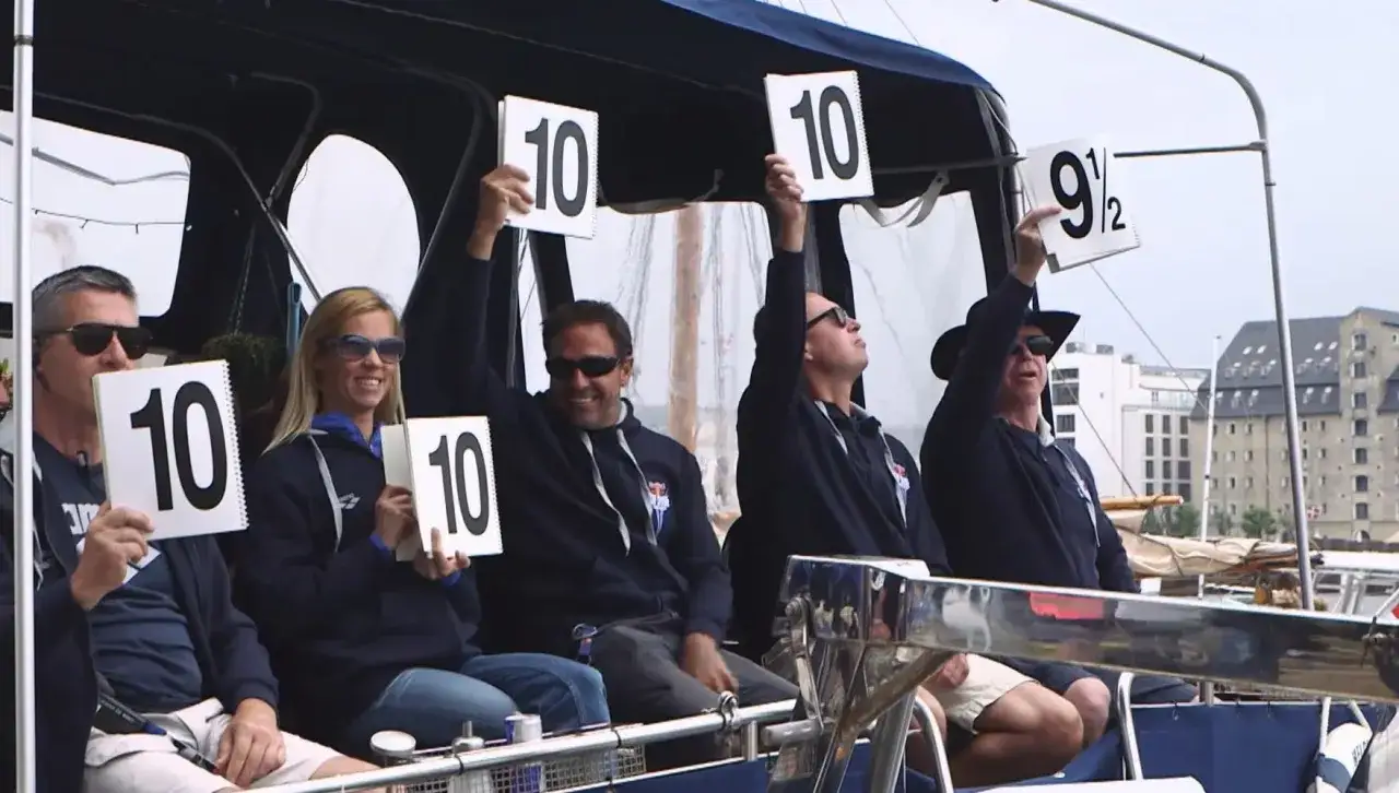 Judges hold up scorecards showing 