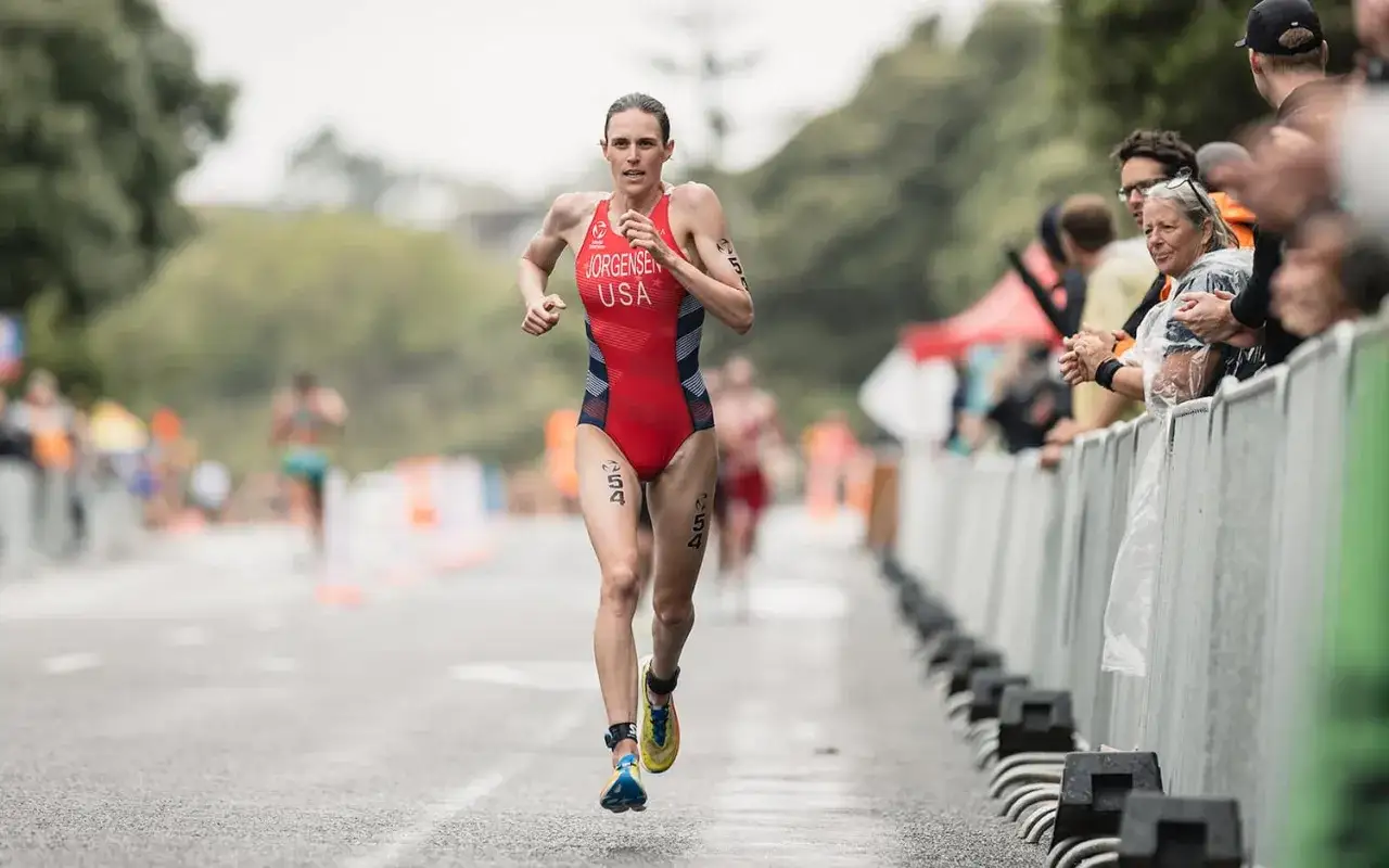 Gwen Jorgensen, one of the world's most famous triathletes, runs during a race, cheered on by spectators.