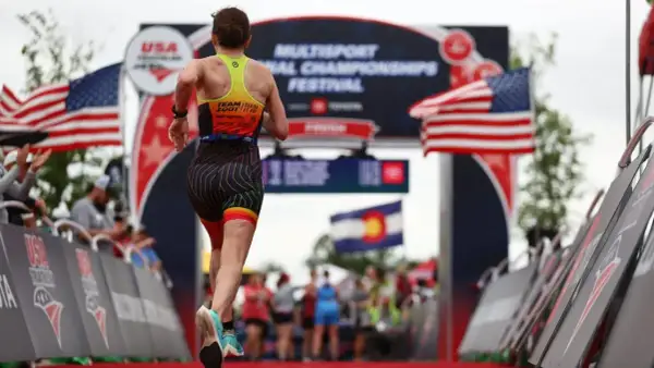 A triathlete runs towards the finish line at the USA Triathlon Multisport National Championships Festival, a testament to their USA Triathlon membership.