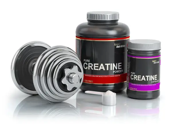 Dumbbells and containers of creatine powder and capsules, ideal for swimmers looking to boost their performance.