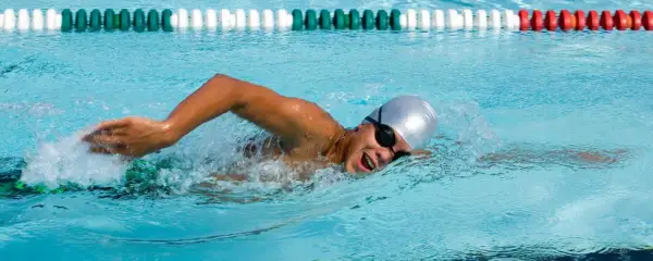 Swimmer in a pool, focused on endurance workouts, powering through the water with determined strokes.