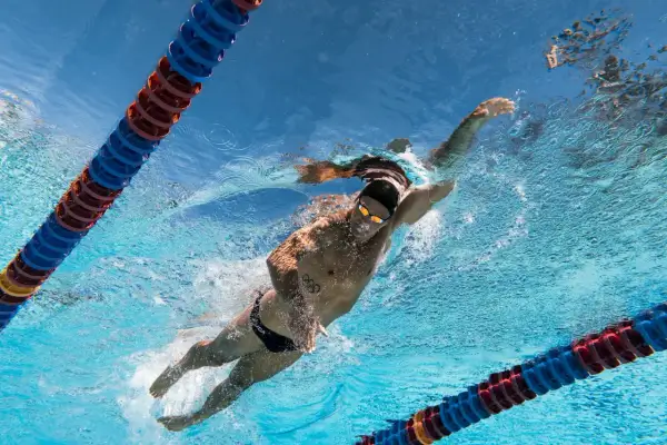 Underwater view of a swimmer performing the backstroke, with lane lines visible. Learn backstroke tips from this powerful stroke.