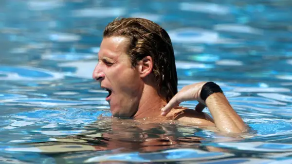 A swimmer gasps for air, his arm reaching back. The resistance of the water explains why does the pool make you tired.