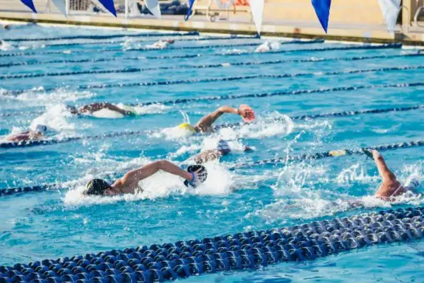 Swimmers push through the water in a competitive race, showcasing an intense hiit swim workout.