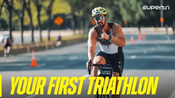 A smiling man on a bike gives a shaka sign, ready for his first triathlon. He's a perfect example of triathlon newbies embracing the challenge.