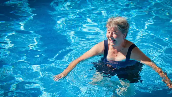 Smiling woman enjoys a refreshing swim, proving you can swim with a pacemaker and live life to the fullest.