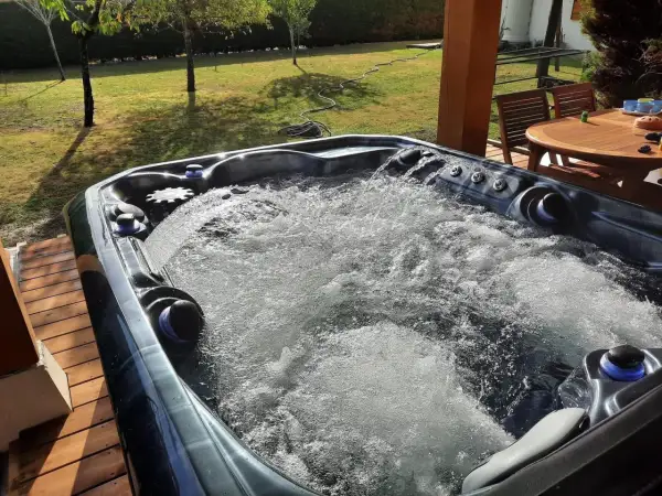Bubbling hot tub on a sunny deck. Wondering how long after a tattoo can you go in a hot tub? This one looks inviting!