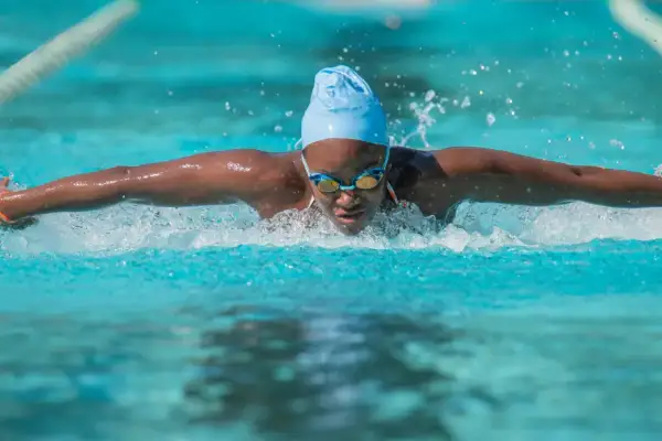 A swimmer powers through the water, a blur of motion and spray. This intense workout is a great way to burn swim calories.