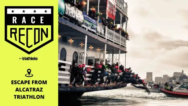 Athletes dive from a boat into the water for the Escape from Alcatraz Triathlon.