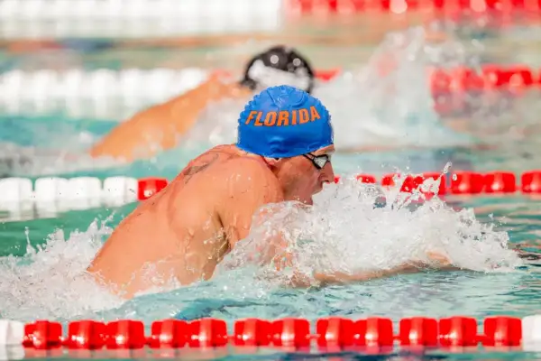 Ryan Lochte, wearing a blue "Florida" cap, powers through the water during intense swim workouts.